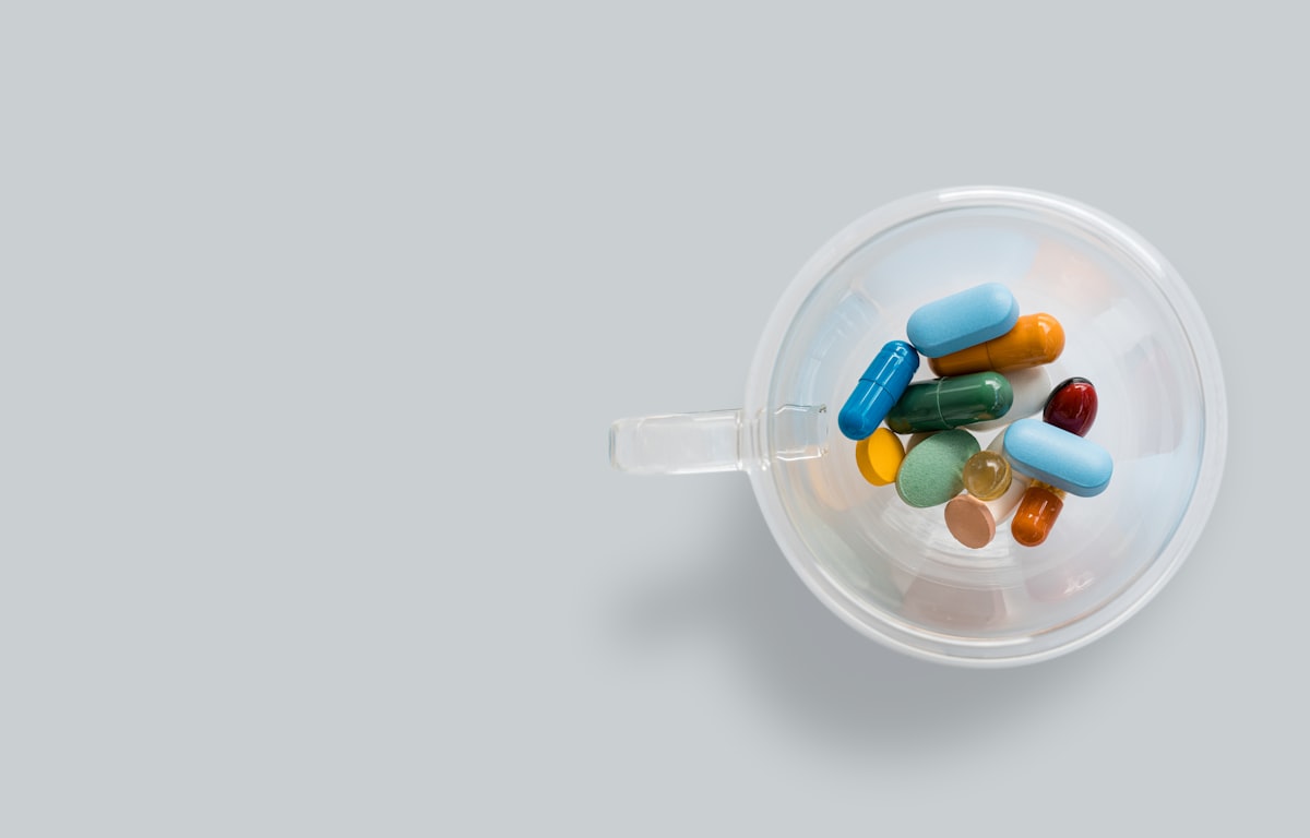Medical documents and prescription bottles arranged with passport on desk