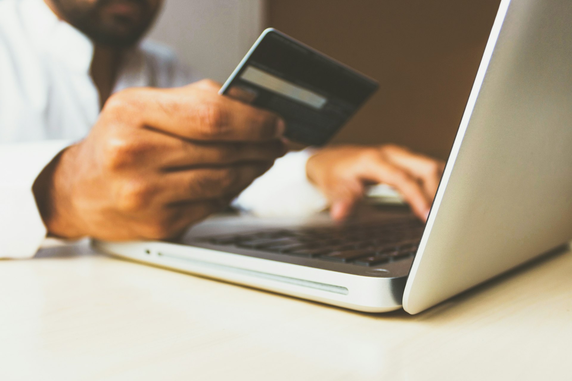 Person using online banking on laptop with credit cards