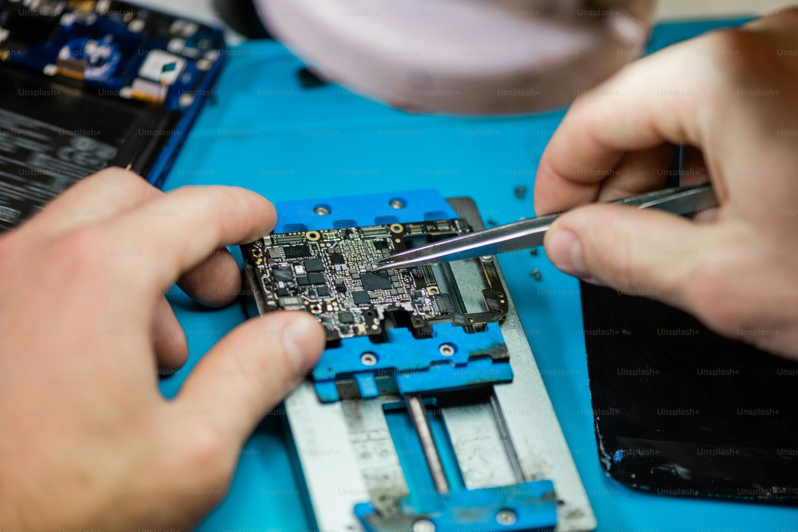 Technician repairing a smartphone on a workbench